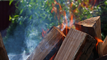 Chopped oak firewood folded like a house flares up in a forest fire
