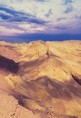 Fototapeta na wymiar Mountainous desert with colorful cloudy sky. Sunset in desert Vertical image