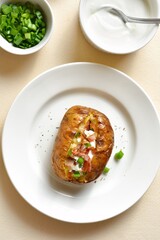 Baked potato with bacon, sour cream and green onion