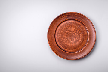 Empty round ceramic plate on a plain background, flatley with copy space