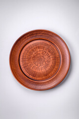 Empty round ceramic plate on a plain background, flatley with copy space