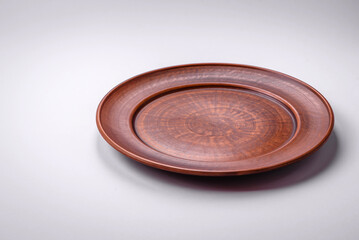 Empty round ceramic plate on a plain background, flatley with copy space