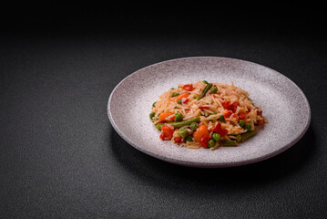 Delicious boiled rice with vegetables peppers, green peas, salt, spices and herbs