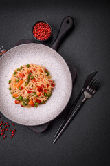 Delicious boiled rice with vegetables peppers, green peas, salt, spices and herbs