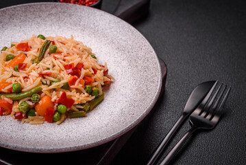 Delicious boiled rice with vegetables peppers, green peas, salt, spices and herbs