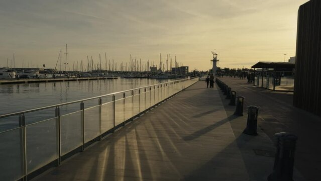 Yachts at the dock in the port of Castellon in the evening of winter. The masts of the yachts sway against the sky. Port Grao