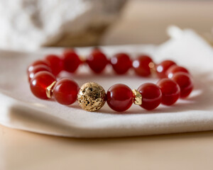 a close-up of a bracelet on the hand made of red carnelian, a stone of health, well-being and success in all matters.