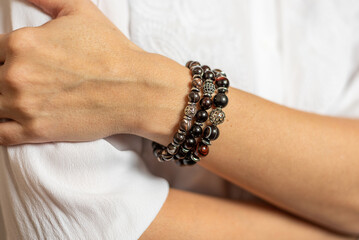 a woman's hand with bracelets made of stones Tiger's eye and bull's eye for businessmen and people...