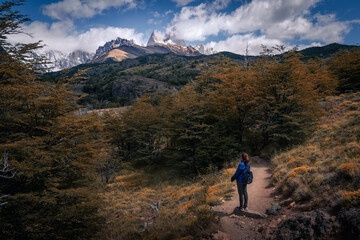 Fototapeta premium A woman with blue cloth looking at to the Mt.Fitz roy with beautiful clouds and sky (Patagonia, El chalten, Argentina)