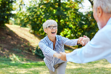 woman man senior couple happy retirement together elderly freedom carefree dancing portrait active vitality bonding park outdoor fun love