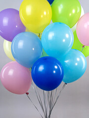Fountain of colorful air balloons of bright colors on a gray background close-up