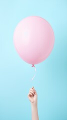 Graceful Hand Clasping a Pink Balloon Against a Tranquil Blue Sky. Generative AI