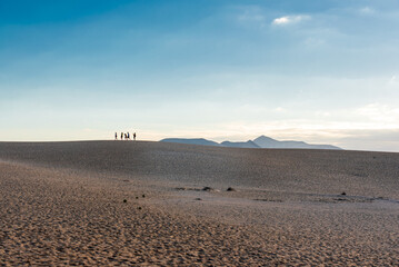 Silhouettes of people on sand dunes on Fuerteventura
