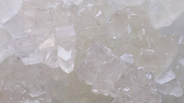 White rock candy sugar crystals or Dhaga Mishri (Crystal Sweet Candy, Patika Bellam, Khadi Sakar, Kuja Misri) circle rotation close up top view