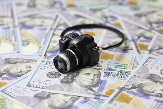 Camera model on US dollar banknotes. Concept of photographer earnings, photo industry