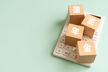 Obraz premium 国民年金の文字が入ったブロックと電卓
