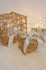 Wicker gift box with a white bow on a white fur background