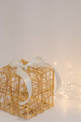Wicker gift box with a white bow on a white fur background