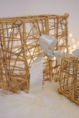 Wicker gift box with a white bow on a white fur background