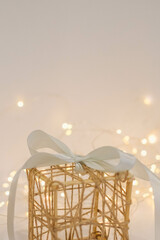 Wicker gift box with a white bow on a white fur background