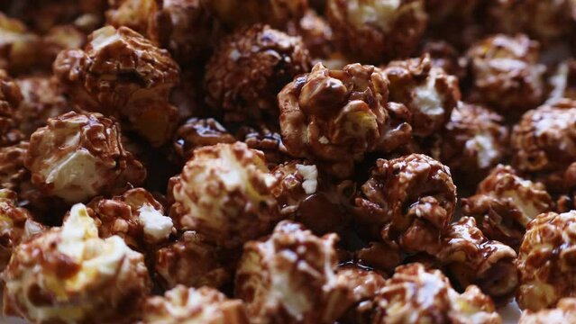 Sweet chocolate or caramel glazed popcorn falling down close up