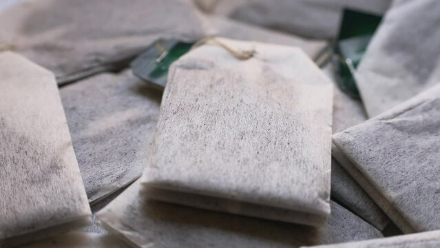 Many paper tea bags with tea circle rotation close up