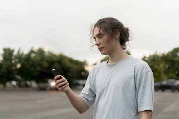 person in the online social media platform; Holding Cell Phone, with Smartphone Outdoors