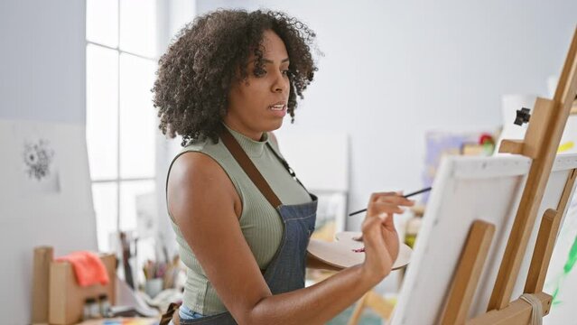 African american woman painting in art studio