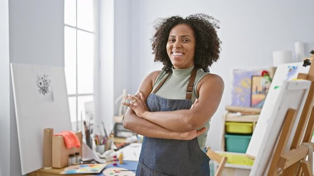 Confident artist woman with curly hair in studio