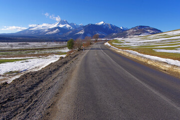Widok na Tatry ośnieżone, droga asfaltowa, oblodzenia, trudne warunki drogowe.