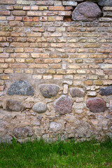 Wall texture with pieces of old bricks mixed with exposed round stones.