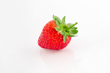 Fresh organic strawberries on a white reflective surface. Close up shot.