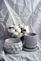 Spa still life with candle and cotton flower on white fabric background