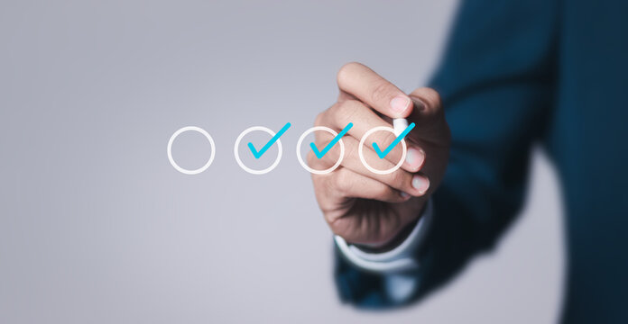 Businessman tick virtual checklist and takes online assessment survey test for approve quality assurance and ERP management, Quality management with assurance, Quality control and improvement.