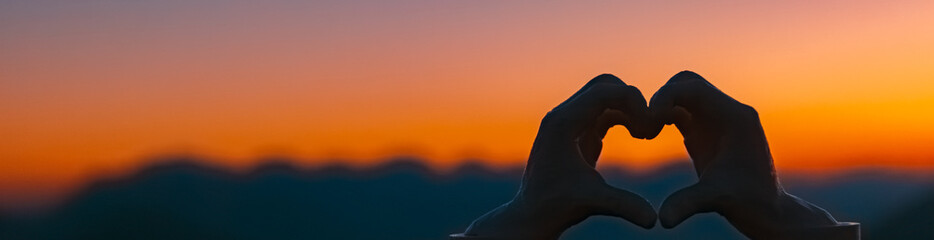 Heart hands gesture silhouette at sunrise, Mount Sechszeiger, Jerzens, Imst, Tyrol, Austria