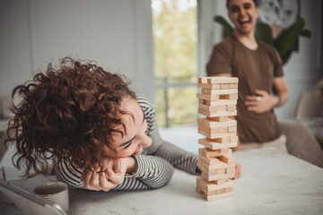 Young woman and man couple playing board games at home, having fun and enjoying weekend vacation