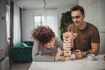 Young woman and man couple playing board games at home, having fun and enjoying weekend vacation