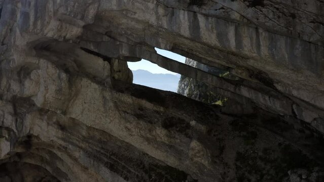 Aerial Forward Shot Of Male Tourist Walking In Rock Formation During Vacation - French Alps, France