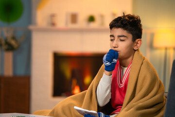 Young teenager sick kid suffering from cough and fever during winter season at home - concept of medical or healthcare problems and viral infection - obrazy, fototapety, plakaty