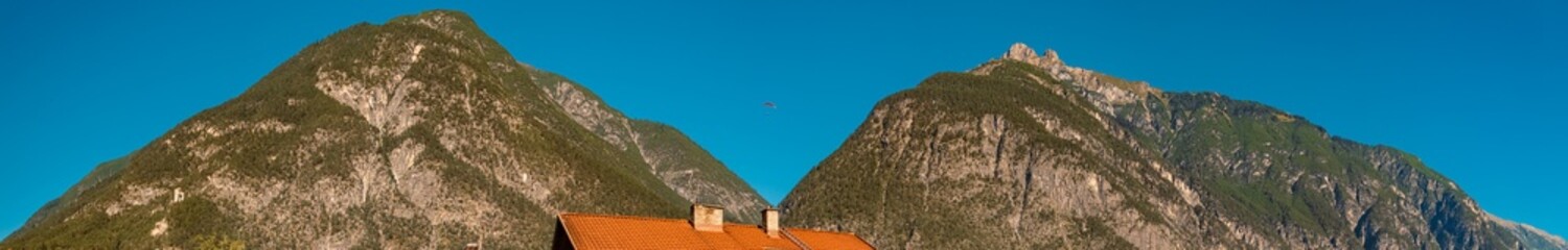 Fototapeta premium High resolution stitched alpine summer panorama with a paraglider at Zams, Landeck, Tyrol, Austria