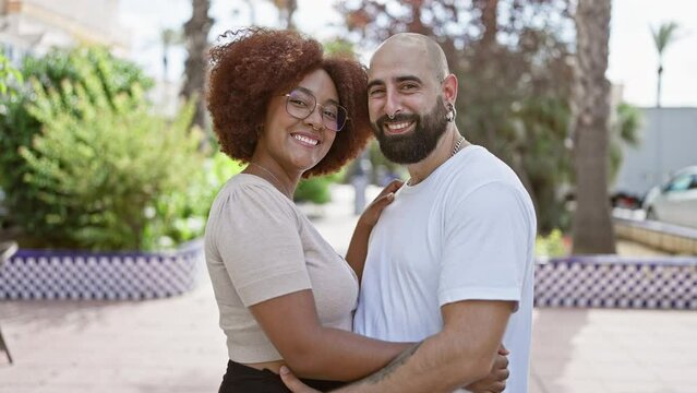 Beautiful couple, full of joy and positivity, hugging and sharing a sunny laugh in an outdoor park. casual, fun love, their confident smiles radiating happiness.