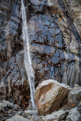 Fototapeta na wymiar Strength and Beauty: A Man at a Mountain Waterfall