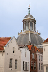 Fototapeta na wymiar Facades of residential houses and with the octagonal baroque domed church - Oostkerk, in the city of Middelburg.