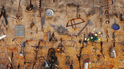 Old rusty utensils decorate the wall. Vintage Wallpaper - obrazy, fototapety, plakaty