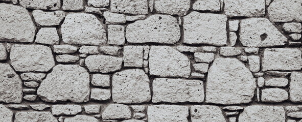 Antique Block Wall. Obsolete Worn Vintage Stone Wall Ancient Texture Grunge background Monochrome Wide Horizontal Photo