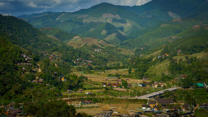 View of many mountains cascading over one another and a small village community distributed in the area below