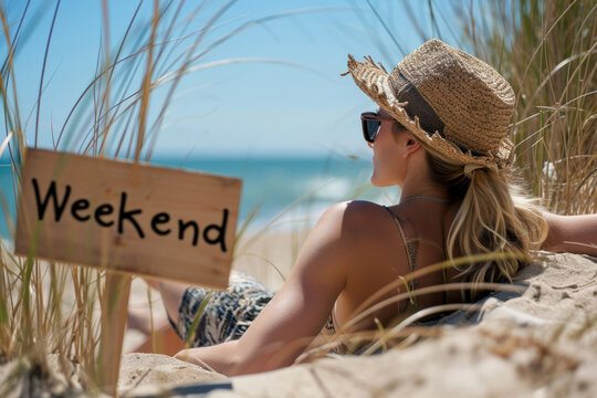 Week end concept image with a woman relaxing and taking a sun bath on her day off with sign with written word Weekend next to her