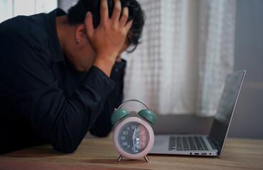 A person diligently typing on a laptop in a business office, surrounded by a retro alarm clock,...