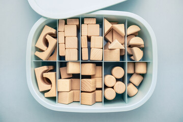 Many wooden geometric toys are kept in the same types of storage box, organization box with...