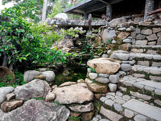 fish pond with a pile or arrangement of natural stones and beautiful roots.